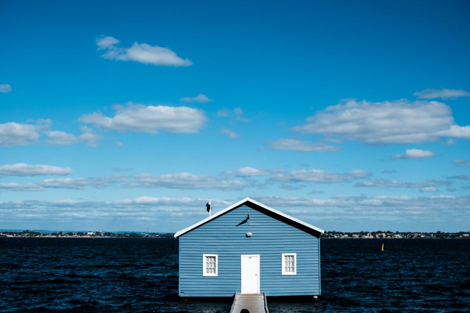 The Blue Boathouse sits majestically on Swan River, Perth, under a vibrant sky.